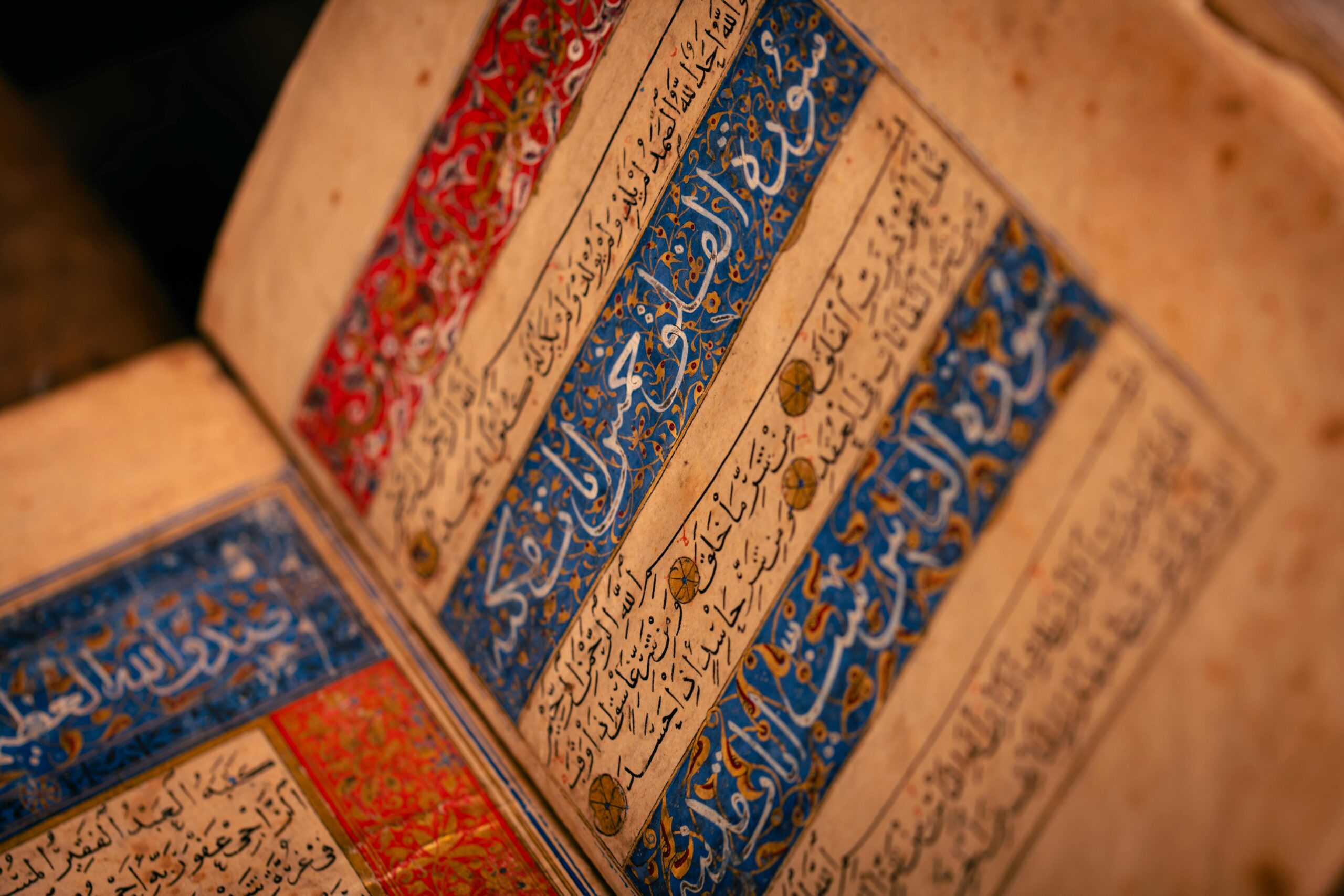 Nos Options Detailed view of an ancient illuminated manuscript with Arabic script and intricate designs.