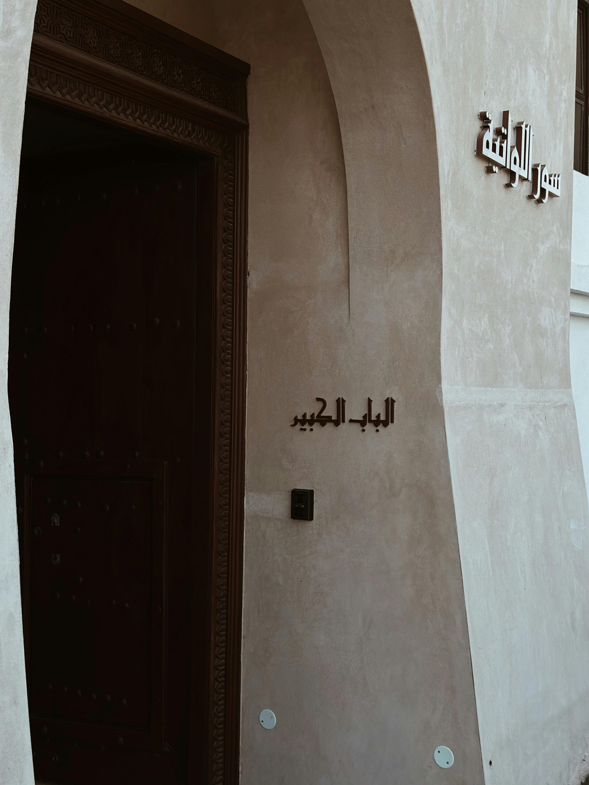 Accueil Elegant Middle Eastern architectural doorway with intricate designs and Arabic text.